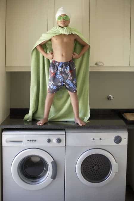 Young Boy Standing on Laundry Machines; supertaster