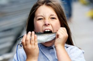 a girl eating fish, a brain food