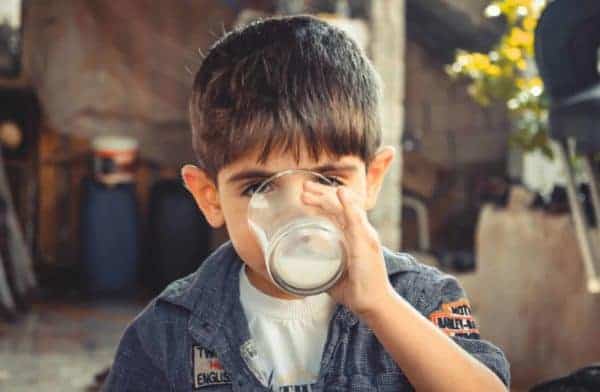 a boy drinking milk, a vitamin D food