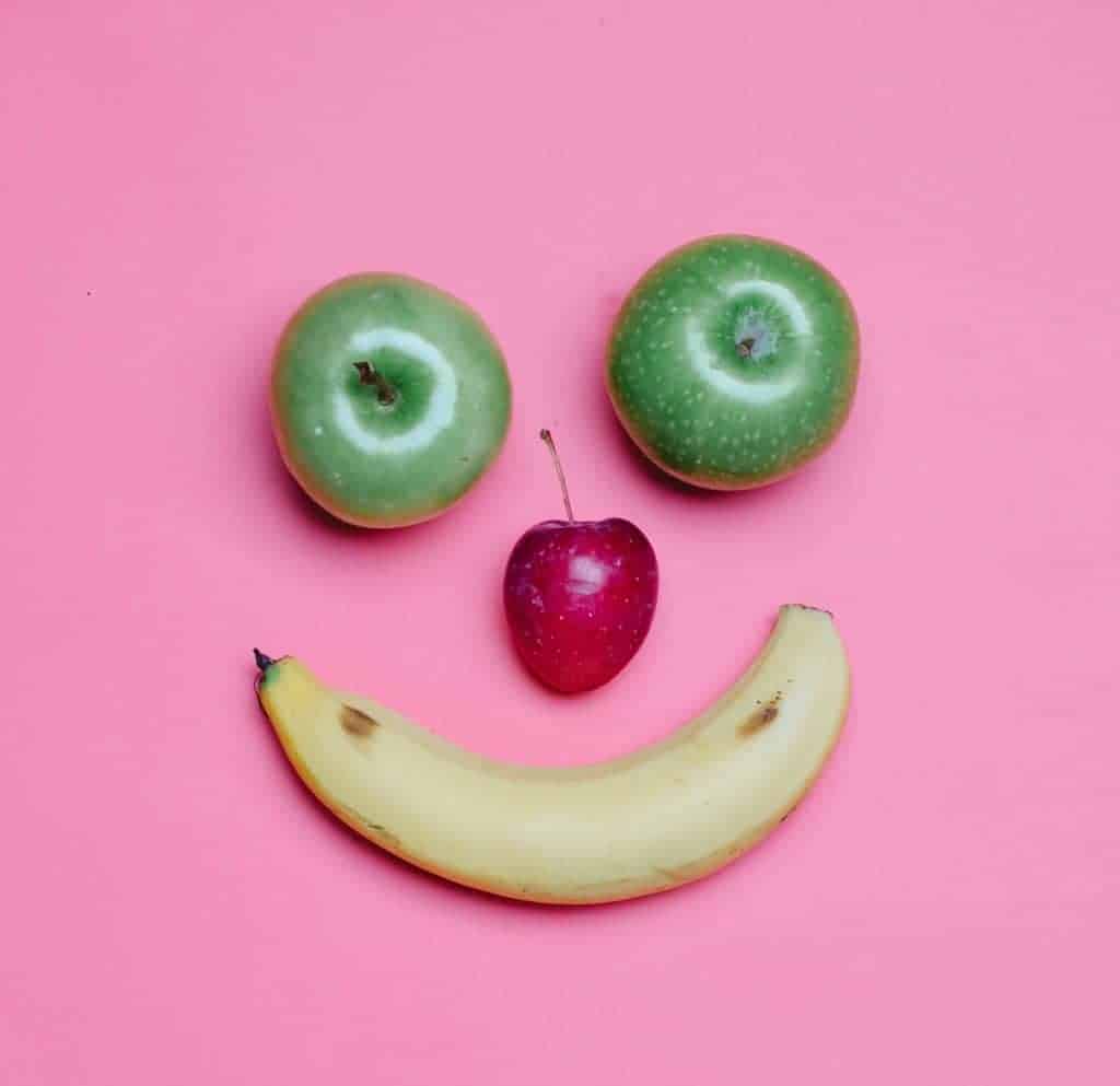 A smile face made with apples, cherry and banana. In Toddler Portion Sizes article.