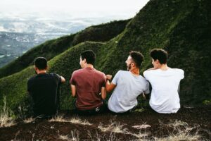 guys sitting on a mountain top